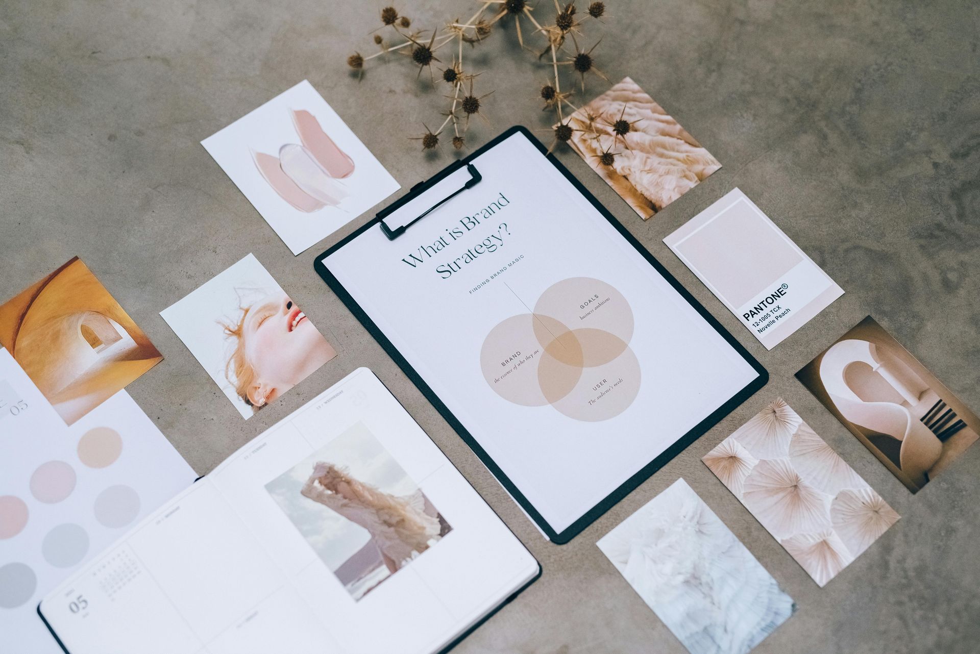 Flat lay of a minimalist brand mood board with pastel cards, abstract prints, and a central color palette sheet
